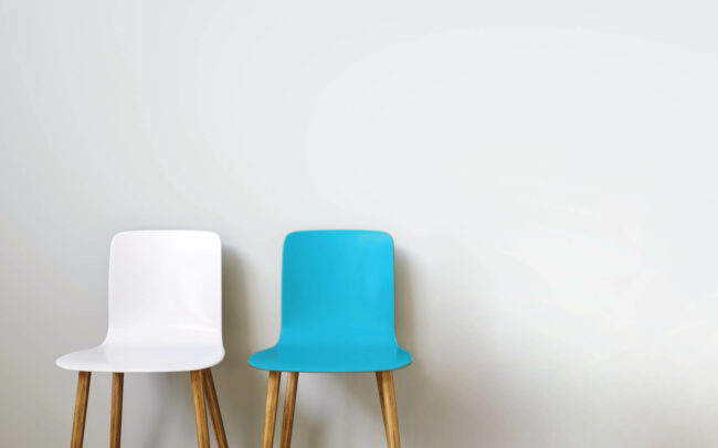 Chairs in arranged in front of a grey wall, with copy space for